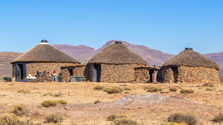 Unidentified Basotho people in front of a rondavel, Lesotho
